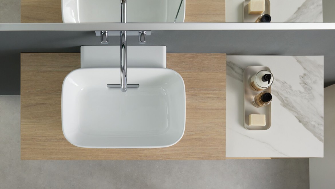 Aufsatzwaschbecken in Schalenform der Badserie Geberit ONE kombiniert mit der Waschtischplatte in Steinzeug in Marmoroptik weiß.