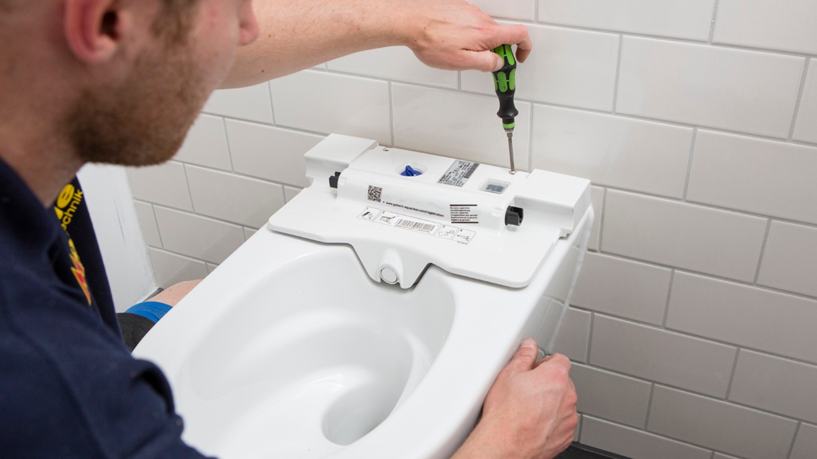 Installateur montiert ein Geberit AquaClean Dusch-WC Sela. Installateur montiert ein Geberit AquaClean Dusch-WC Sela.