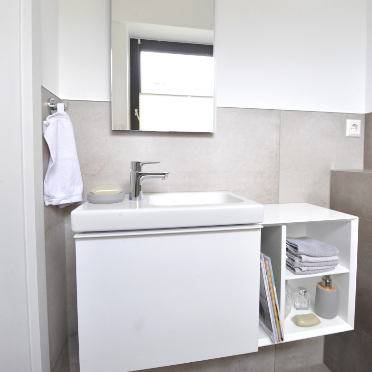 Gästebad mit Stauraum dank Waschtischunterschrank und Seitenelement Gästebad mit Stauraum dank Waschtischunterschrank und Seitenelement