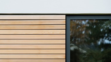 Fassade des Doppelhauses mit schönen Details wie einer horizontalen Holzschalung