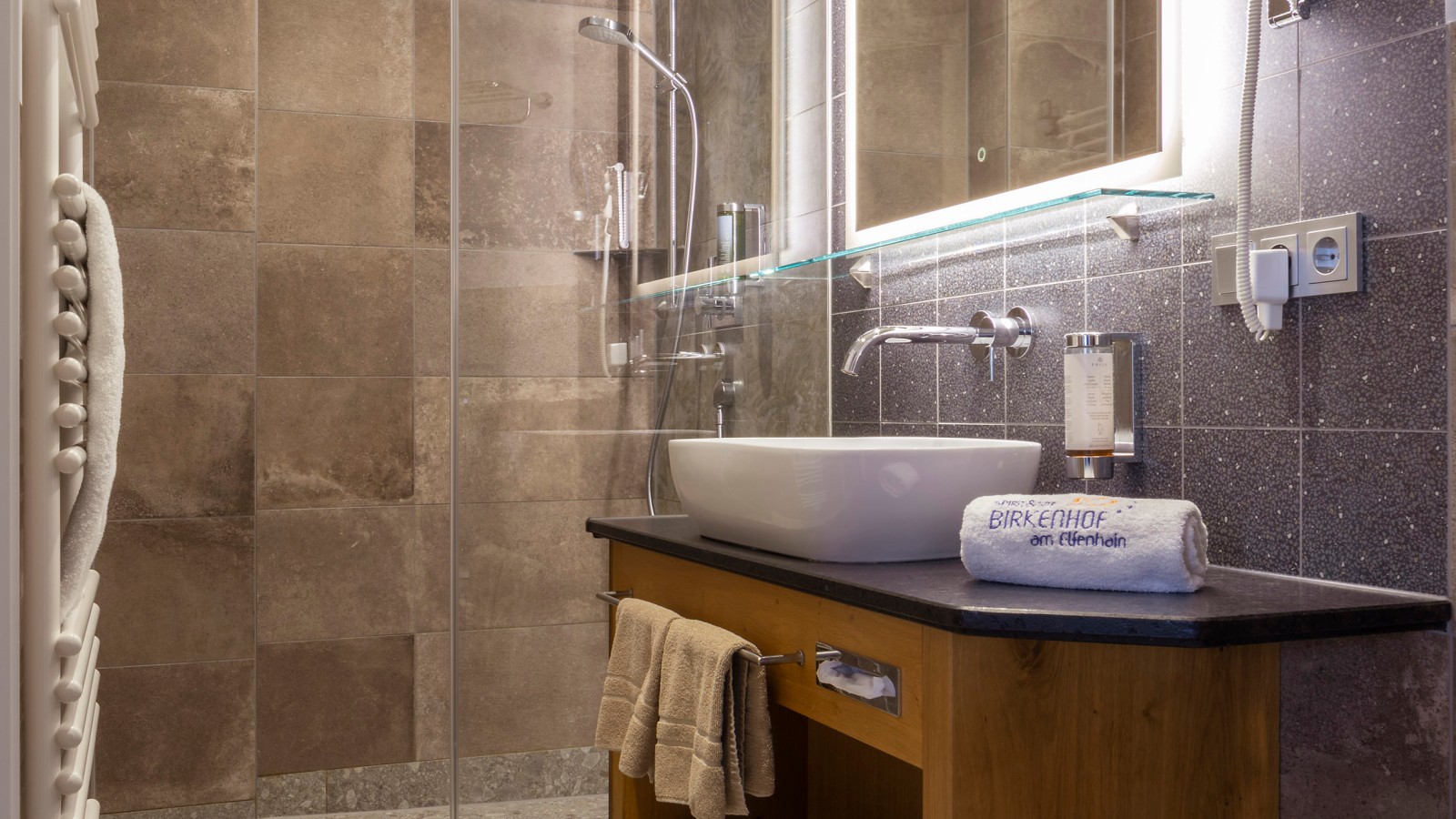 Ein Bad ausgestattet mit bodenebener Dusche und Geberit Dusch-WC AquaClean Sela. Ein Bad ausgestattet mit bodenebener Dusche und Geberit Dusch-WC AquaClean Sela.