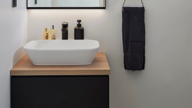 Waschplatz im Gästebad mit Geberit ONE Aufsatzwaschtisch und Unterschrank kombiniert mit Option Plus Square Lichtspiegel.