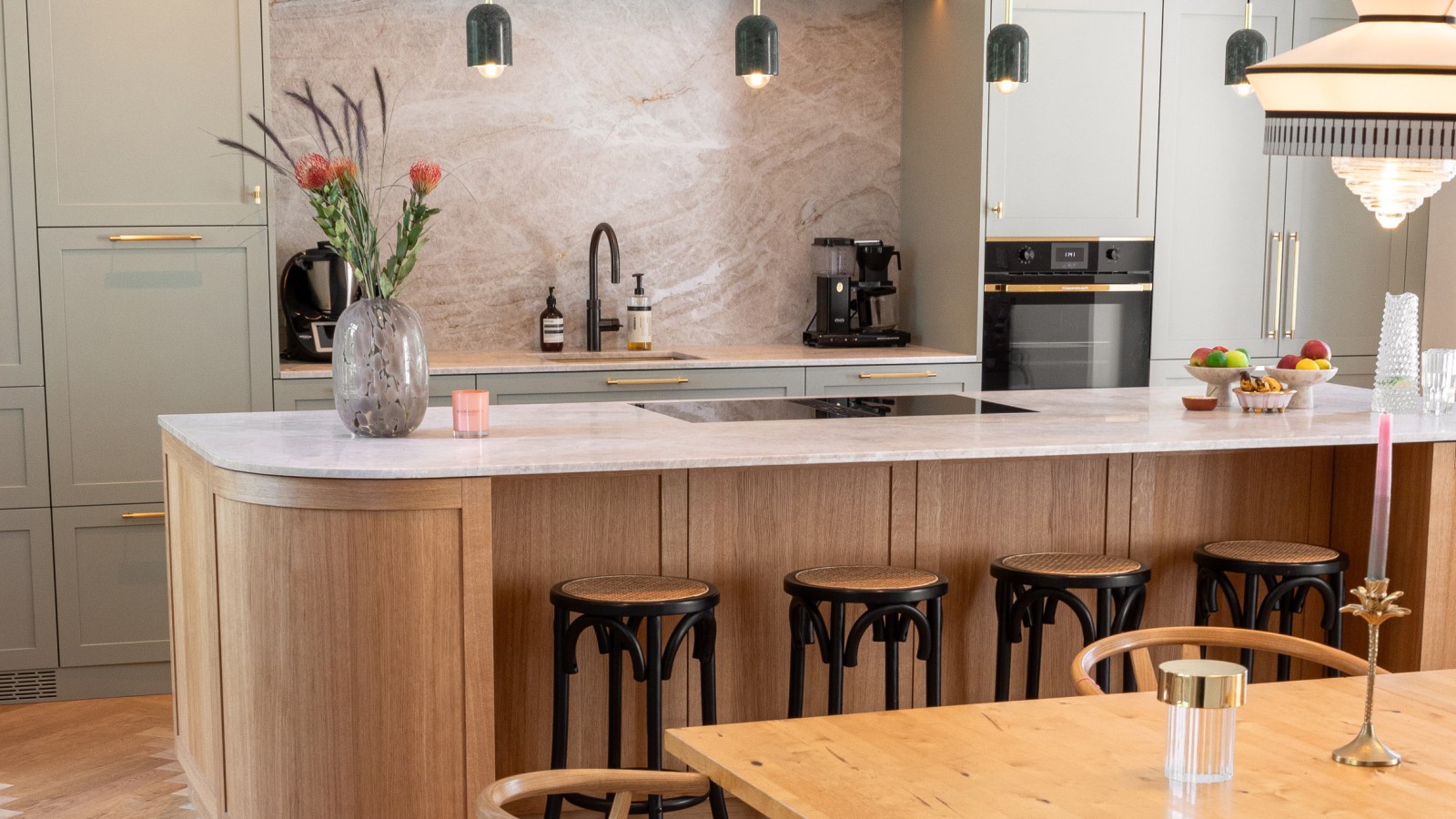 Offene Küche in pastellgrün und warmen Holztönen.