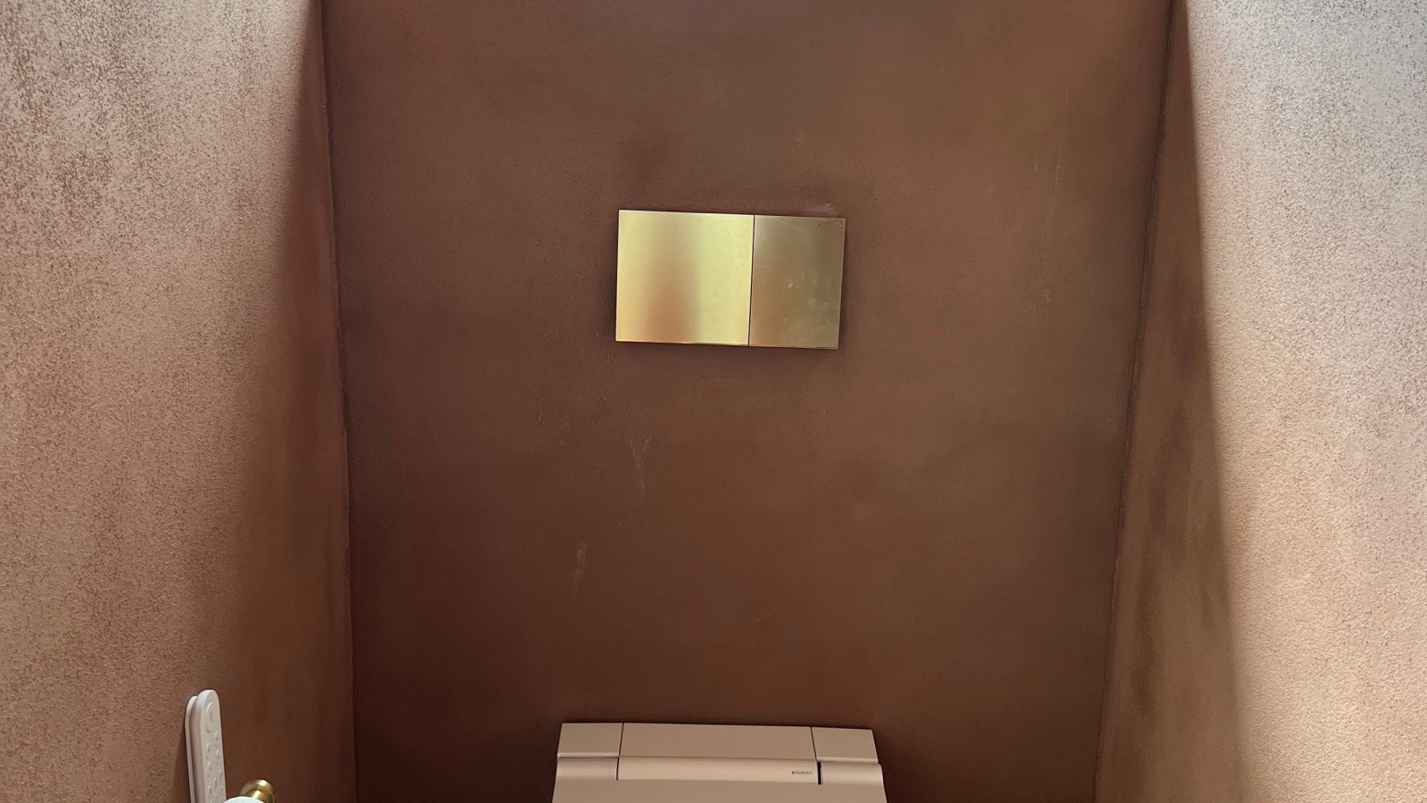 Das AquaClean Sela Dusch-WC und die Betätigungsplatte Sigma70 in Messing wurden im Gäste-WC installiert. Das AquaClean Sela Dusch-WC und die Betätigungsplatte Sigma70 in Messing wurden im Gäste-WC installiert.