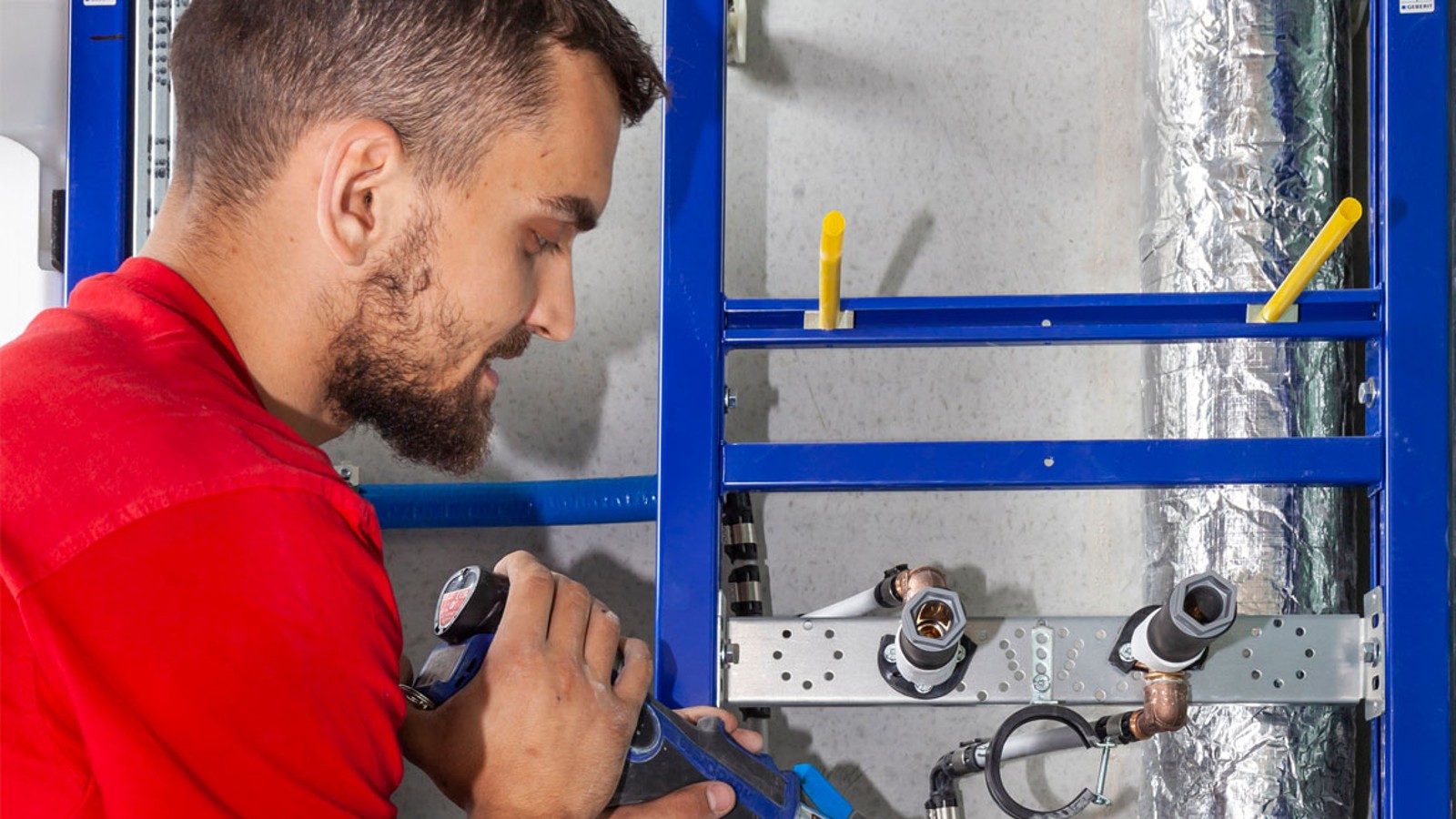 Monteur verarbeitet das Versorgungssystem Geberit FlowFit Monteur verarbeitet das Versorgungssystem Geberit FlowFit