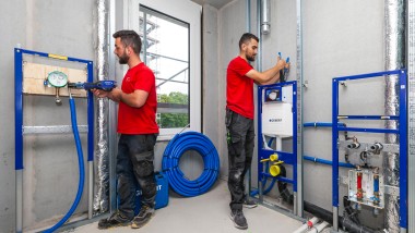 Zwei Monteure installieren die Geberit Sanitärtechnik im Quartier St. Johannes Maria Vianney