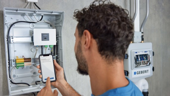 Mann steuert Geberit Gateway über die Geberit Control App. Mann steuert Geberit Gateway über die Geberit Control App.