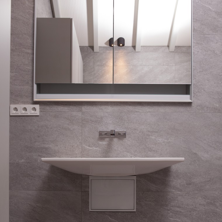 Waschplatz ausgestattet mit Waschtisch und Spiegelschrank der Serie Geberit ONE.
