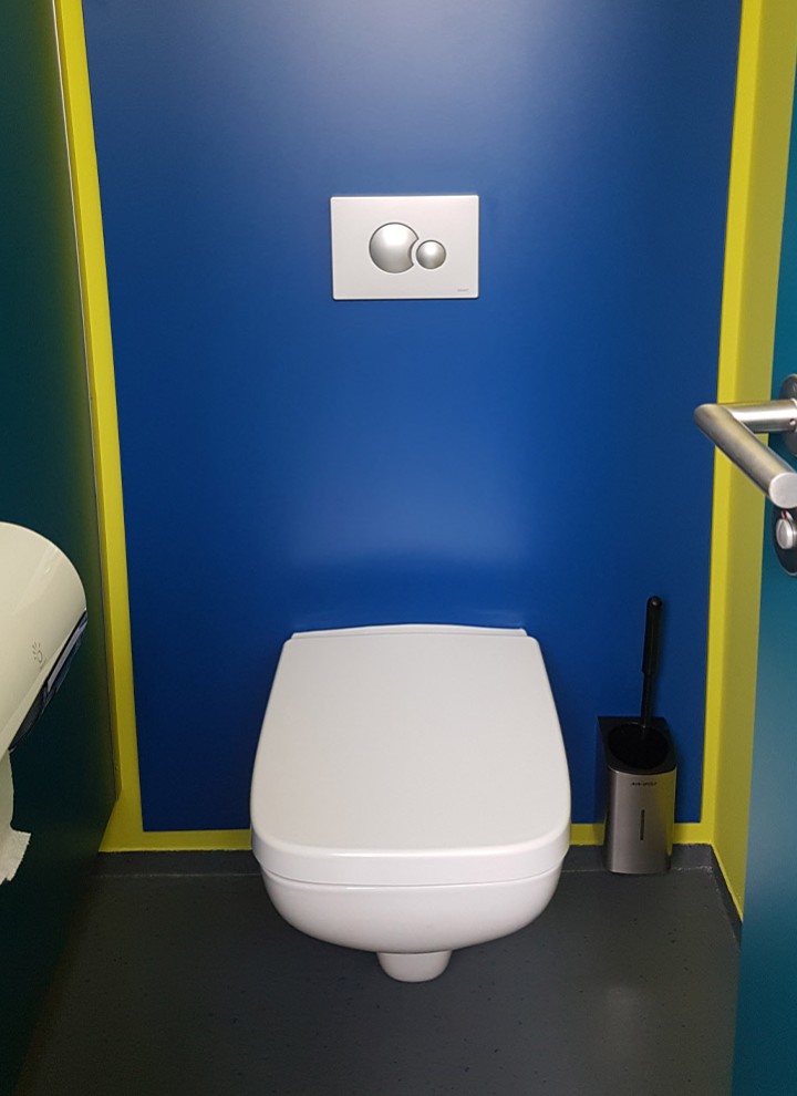 Moderne Farbgestaltung in der Toilettenkabine in Blau und Gelb