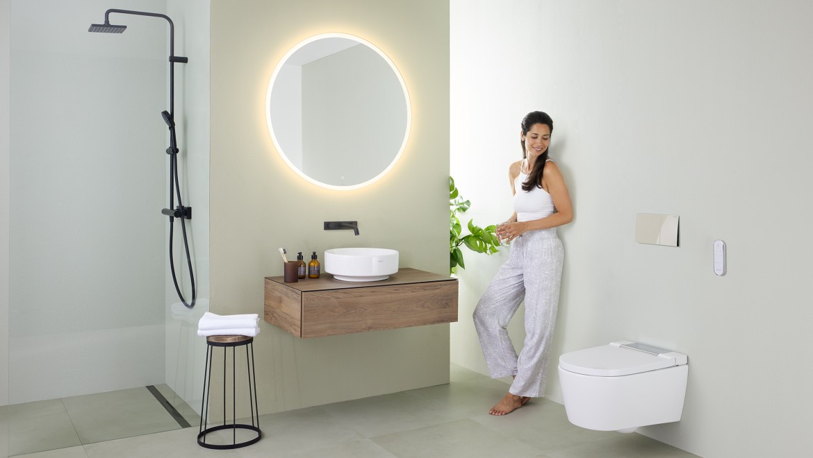 Frau in minimalistisch eingerichtetem Badezimmer Frau in minimalistisch eingerichtetem Badezimmer