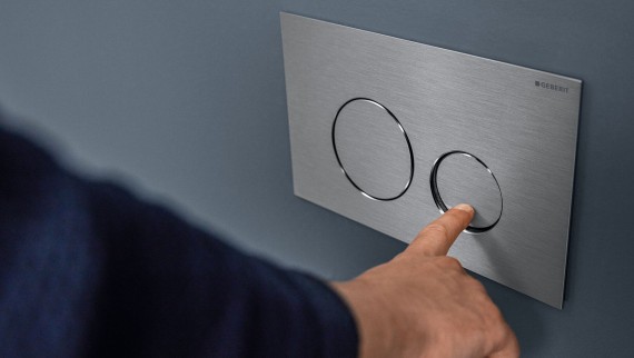 Hand löst kleine Spülung an der Sigma40 Round Betätigungsplatte aus (© Geberit) Hand löst kleine Spülung an der Sigma40 Round Betätigungsplatte aus (© Geberit)
