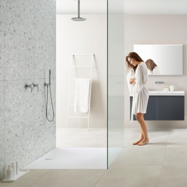 Frau in Bad mit Walk-in-Dusche und Geberit Olona Duschfläche Frau in Bad mit Walk-in-Dusche und Geberit Olona Duschfläche