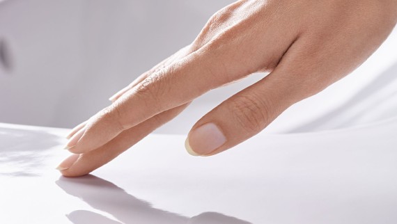 Hand streicht über glatte Keramikoberfläche mit Geberit KeraTect Hand streicht über glatte Keramikoberfläche mit Geberit KeraTect