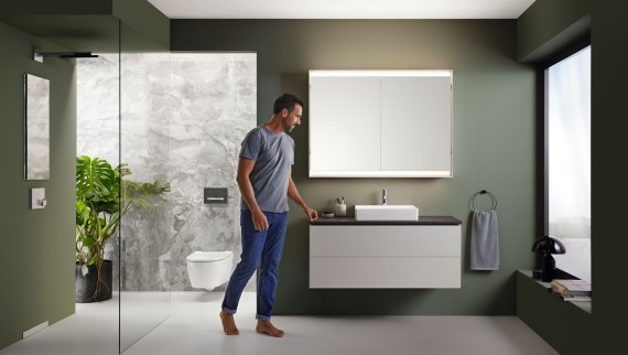 Mann in Geberit Badezimmer mit begehbarer Dusche Mann in Geberit Badezimmer mit begehbarer Dusche