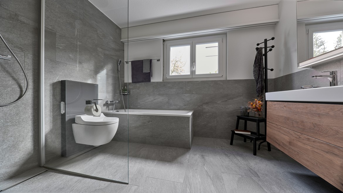 Badezimmer nach der Renovierung ausgestattet mit einem Geberit AquaClean Tuma Dusch-WC und einem Doppelwaschplatz der Serie Geberit ONE.