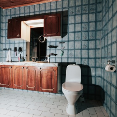 Bad mit blauen Fliesen und bodenstehendem WC