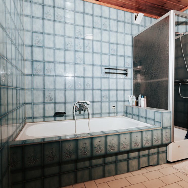 Bad mit blauen Fliesen, Duschkabine und Badewanne Bad mit blauen Fliesen, Duschkabine und Badewanne