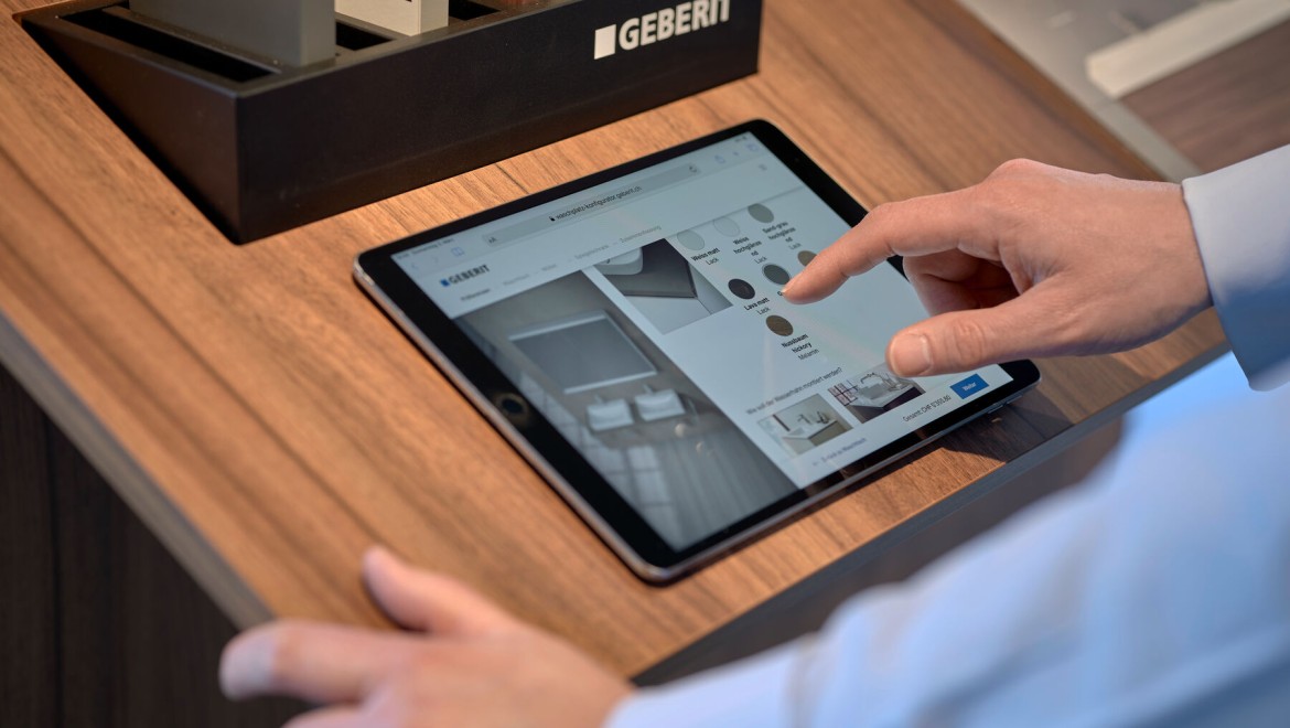 Mann mit Tablet wählt Produkte in einem Konfigurator aus Mann mit Tablet wählt Produkte in einem Konfigurator aus