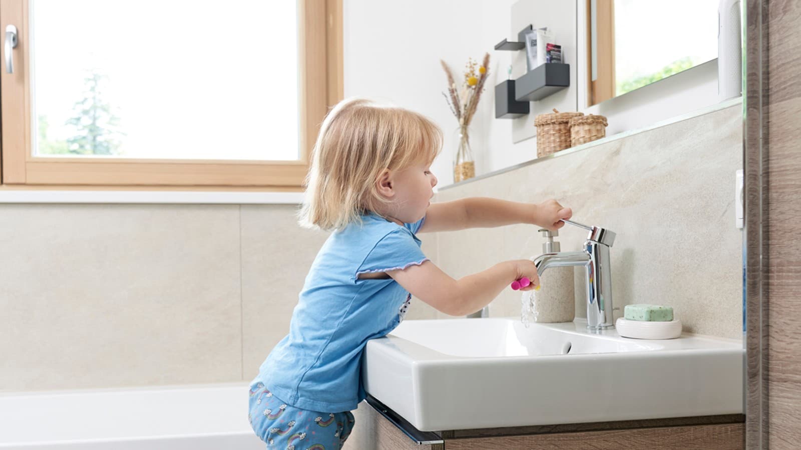 Mädchen wäscht sich die Hände an Geberit iCon Waschtisch Mädchen wäscht sich die Hände an Geberit iCon Waschtisch