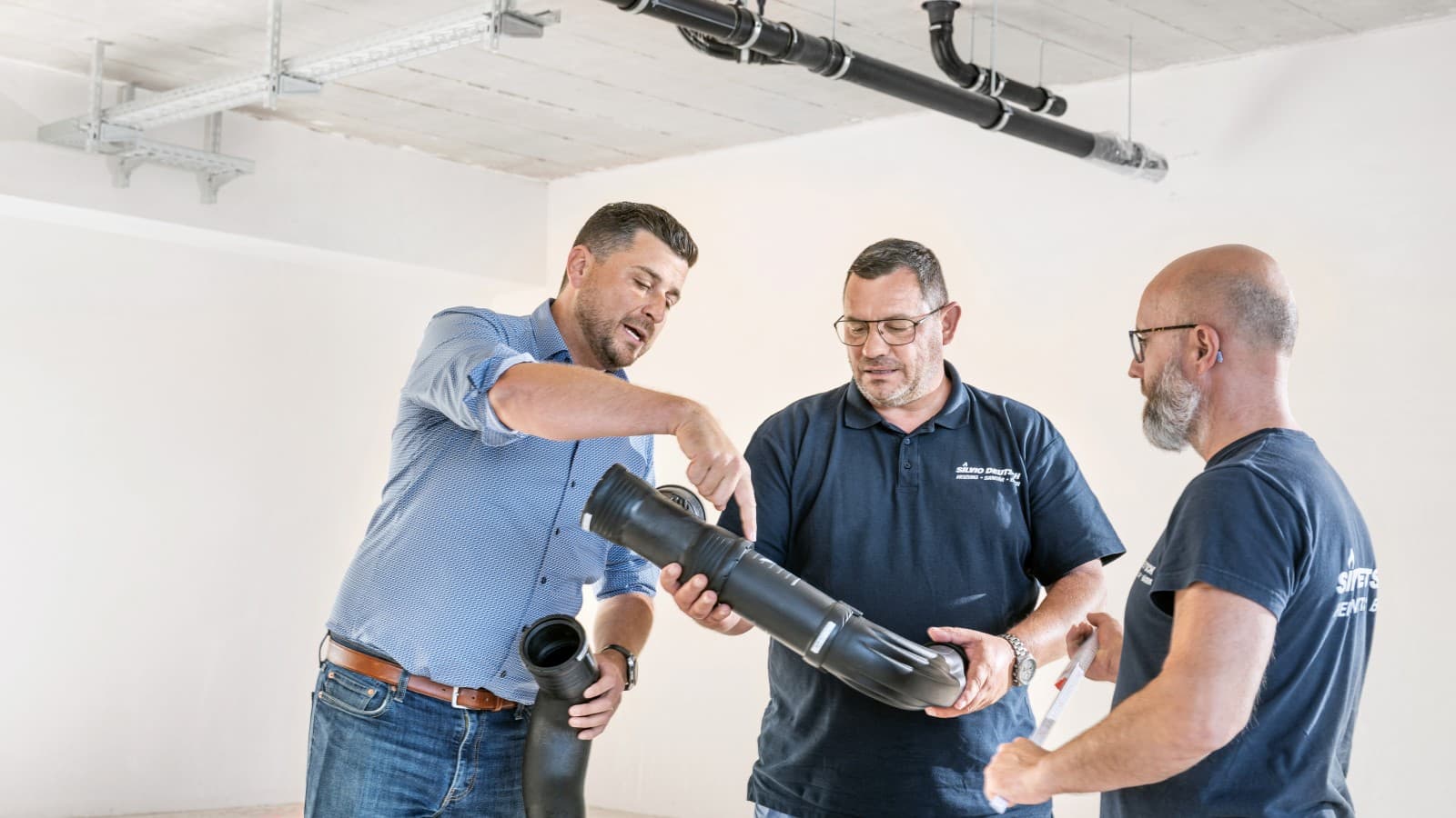 Geberit Verkaufsberater Fabian Ritter erklärt dem Team den neuen Silent-Pro BottomTurn Bogen Geberit Verkaufsberater Fabian Ritter erklärt dem Team den neuen Silent-Pro BottomTurn Bogen