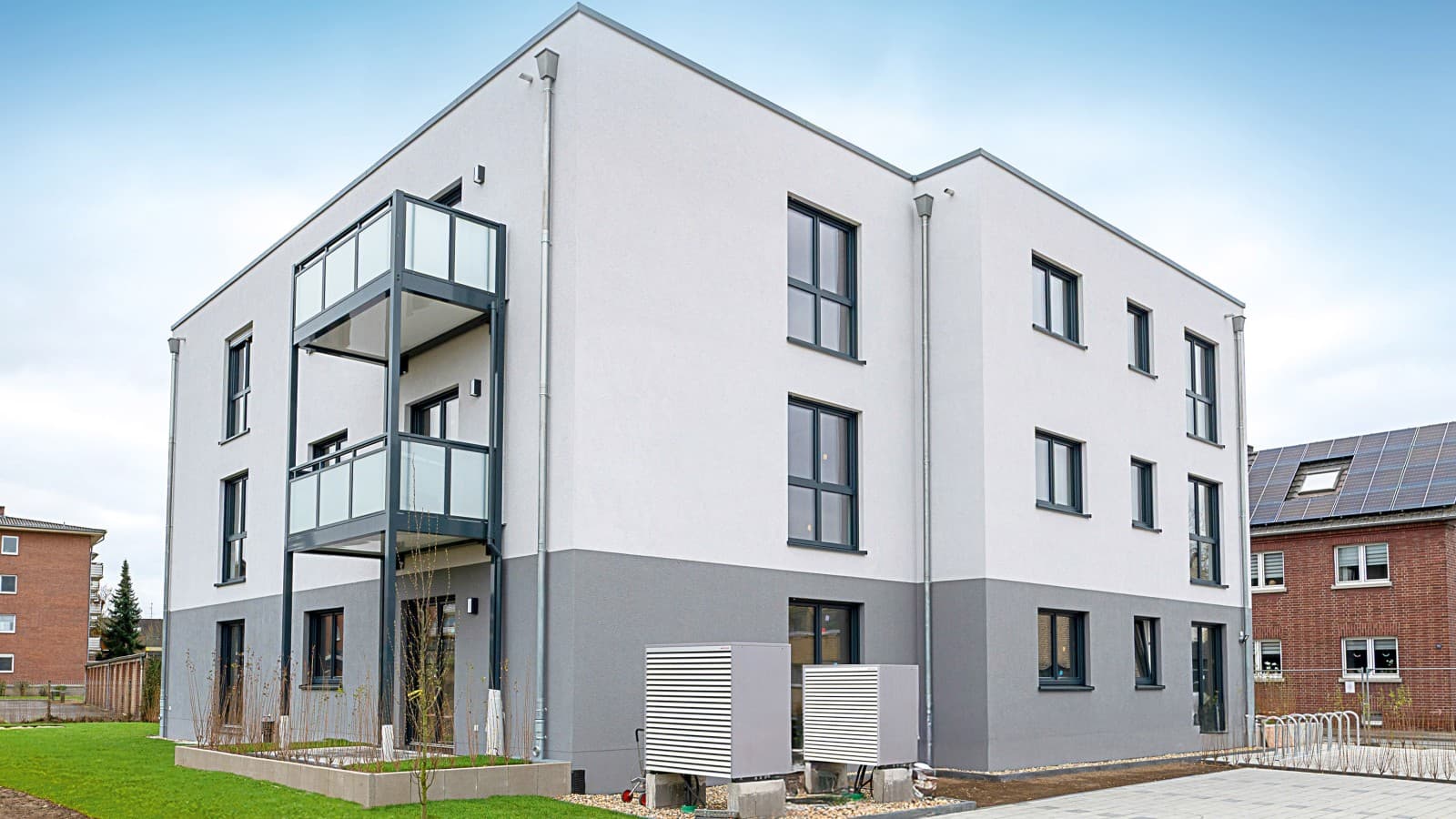 Außenansicht eines Mehrfamilienhaus mit Netto-Null-Standard in moderner Holzbauweise. Außenansicht eines Mehrfamilienhaus mit Netto-Null-Standard in moderner Holzbauweise.