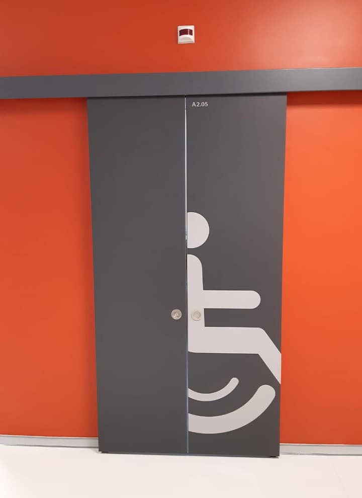 Eingang zur barrierefreien Toilette in Rot und Grau Eingang zur barrierefreien Toilette in Rot und Grau