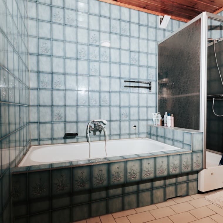 Bad mit blauen Fliesen, Duschkabine und Badewanne Bad mit blauen Fliesen, Duschkabine und Badewanne